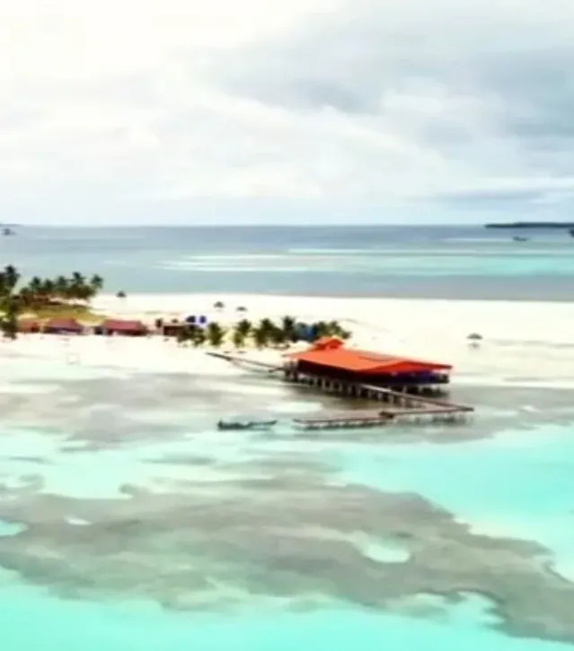 Vista aérea del muelle naranja y la playa entre agua turquesa